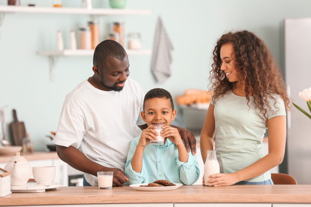 African-American family drinking milk in kitchen