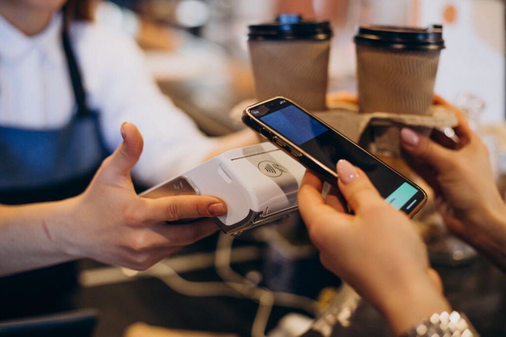 Customer buying coffee at a coffee shop and paying with card Customer buying coffee at a coffee shop and paying with card