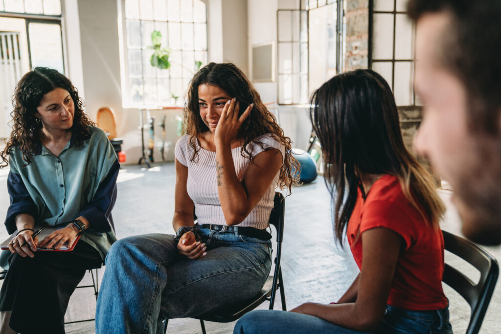 A woman is crying during a group therapy session